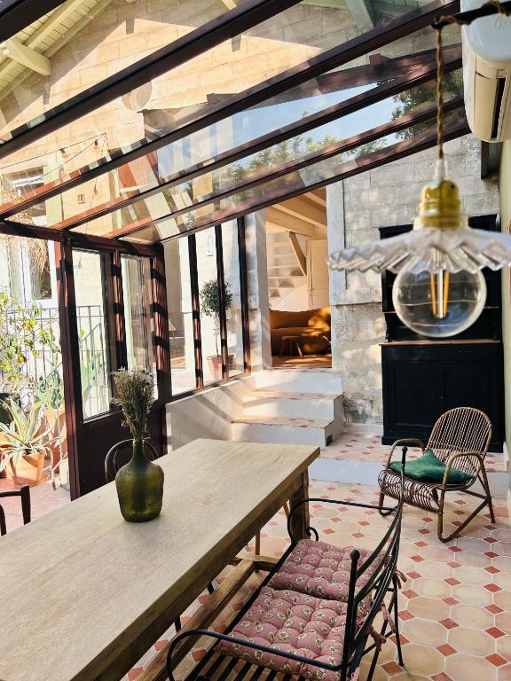 une salle à manger avec une table et une cheminée en pierre dans l'établissement Maison atypique au coeur de Montpellier, cours et parking, à Montpellier