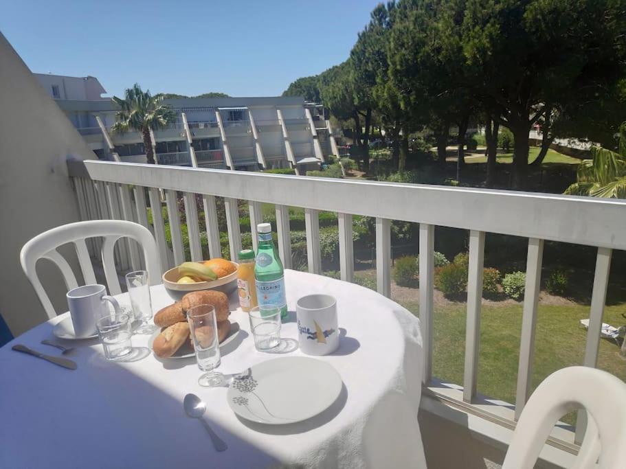 a table with a bowl of food and drinks on a balcony at A la frégate Port-Camargue Grau-du-Roi in Le Grau-du-Roi