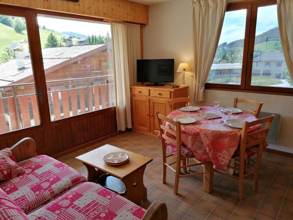 un salon avec une table et un canapé dans l'établissement Appt 2 pièces pour 5 pers avec balcon et parking à Chinaillon, près des pistes - FR-1-241-121, au Grand-Bornand