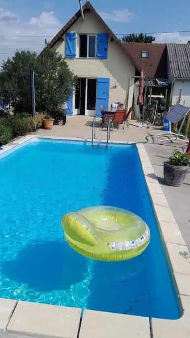 un frisbee jaune est assis dans une piscine dans l'établissement Maison a côté du pal, à Saligny-sur-Roudon