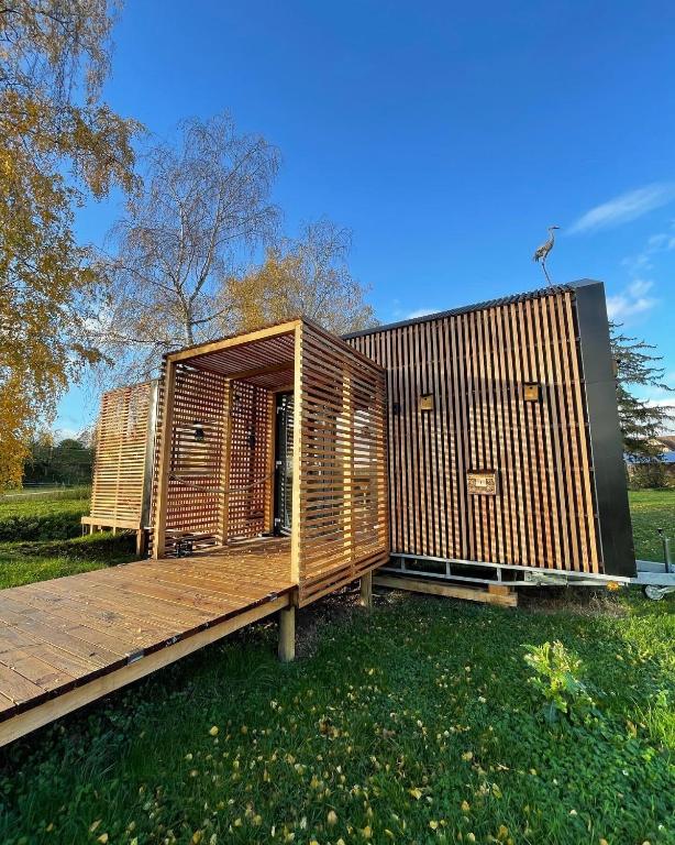 un bâtiment en bois avec une terrasse dans l'herbe dans l'établissement MyCosyTiny, à Griesheim-près-Molsheim