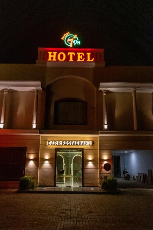 帕格瓦拉Hotel 7 PM的前面有 ⁇ 虹灯标志的酒店