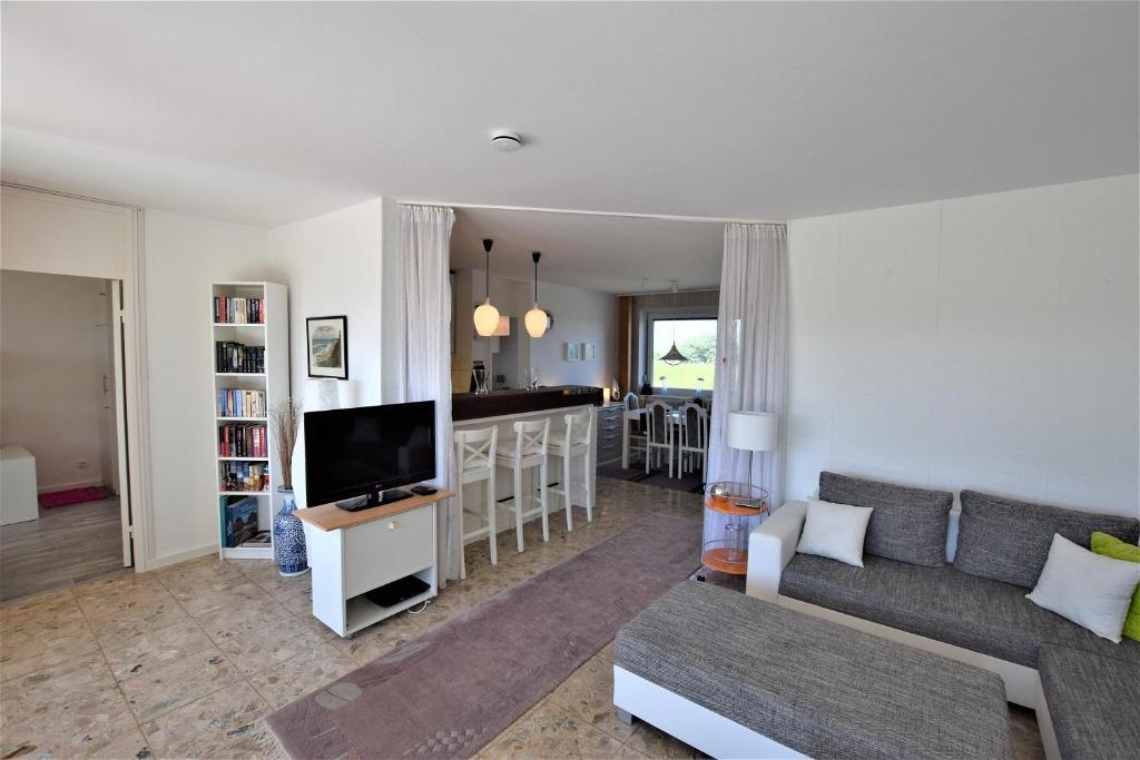 ein Wohnzimmer mit Sofa und Fernseher in der Unterkunft Hohes Ufer Mare Nostrum in Hohwacht