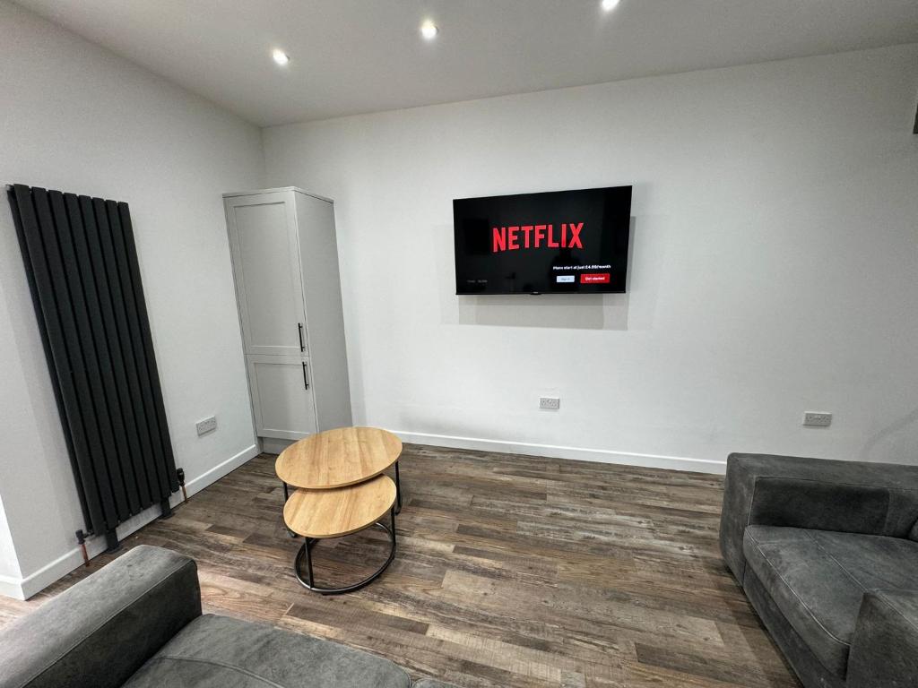 ein Wohnzimmer mit einem Sofa und einem Fernseher an der Wand in der Unterkunft Staywell Hartlepool in Hartlepool