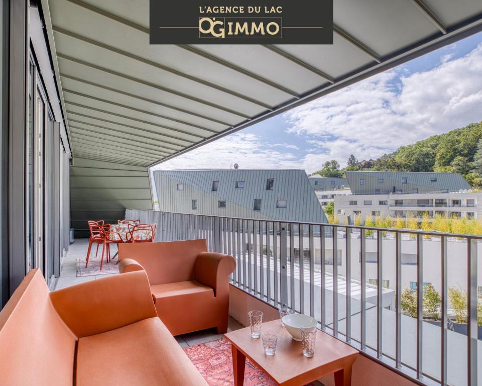 un balcon avec des meubles orange et une vue sur un immeuble dans l'établissement View point Castle, à Annecy