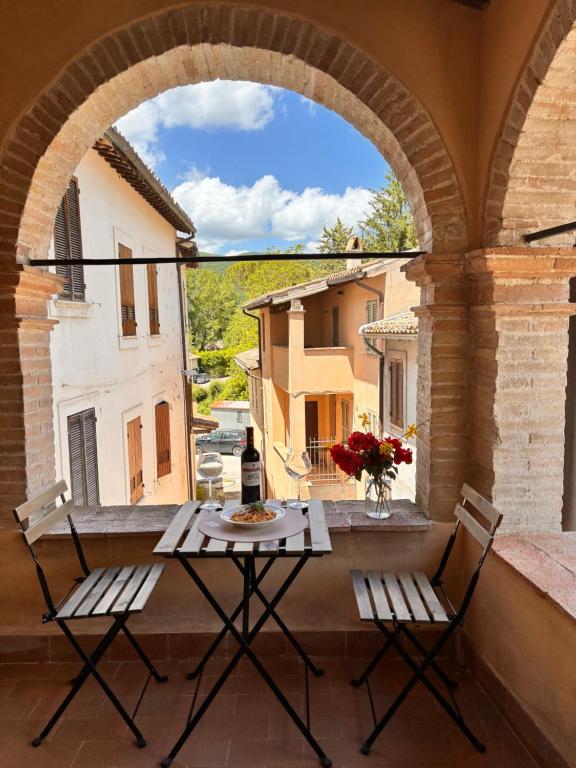 a table and chairs on a balcony with an archway at Casa in Umbria - nella Valle del Menotre vicino Rasiglia, Foligno, Assisi,Perugia in Foligno
