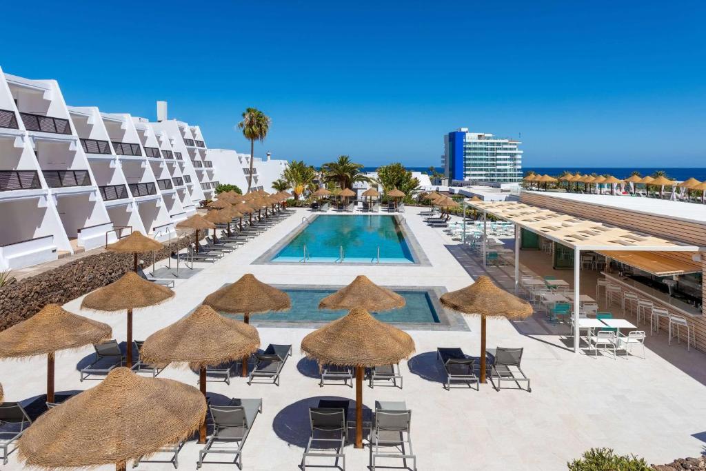 a resort with a pool and chairs and umbrellas at Sol Fuerteventura Jandia - All Suites in Morro del Jable