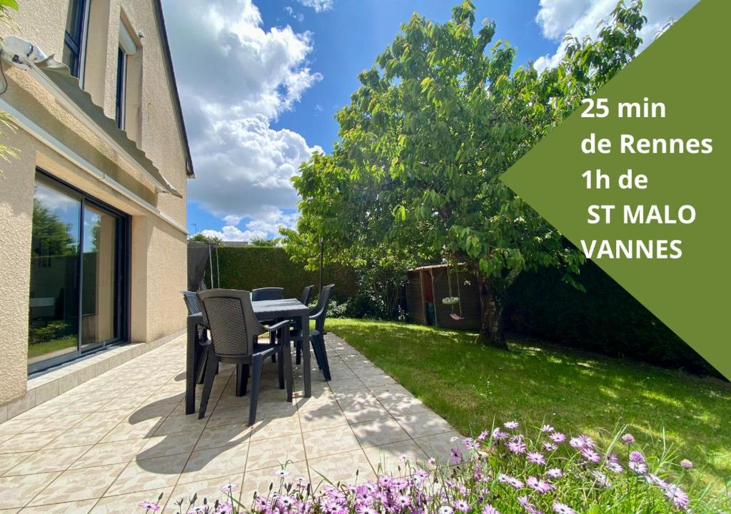 un patio avec une table et des chaises dans une cour dans l'établissement Maison du periel, à Mordelles