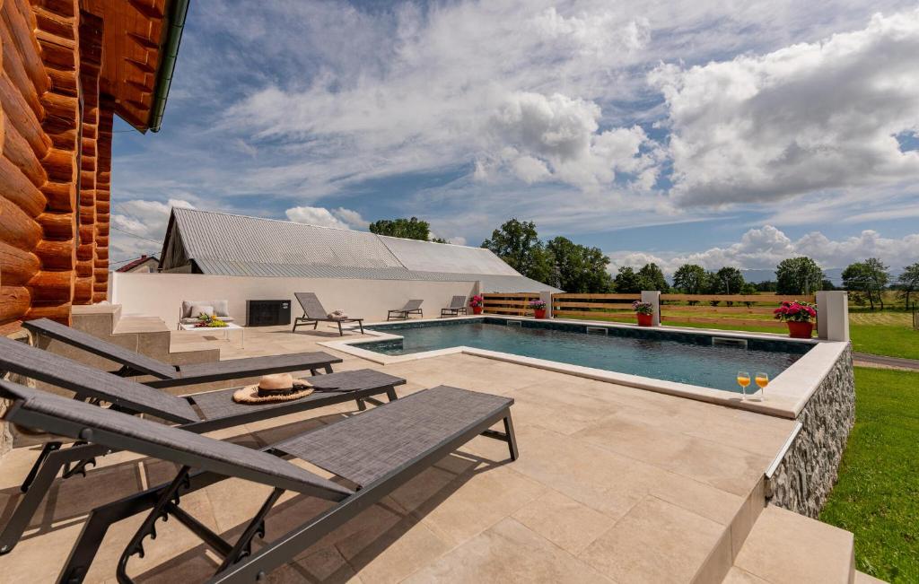 una piscina con mobili da giardino e una casa di Kolibe Lika - The Valley a Mušaluk