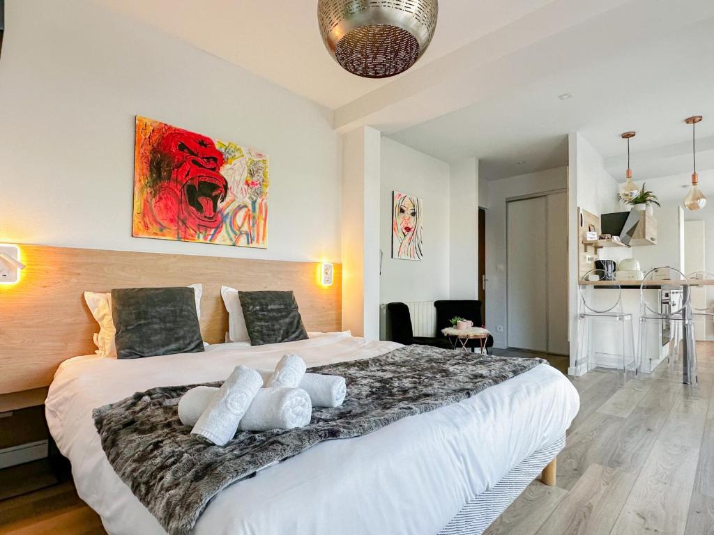 une chambre avec un grand lit avec des oreillers blancs dans l'établissement Art Bay 2 velos parking, à Annecy