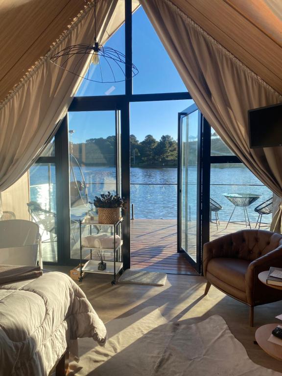 a bedroom with a view of the water at Celeiro Lake Village in São Francisco de Paula