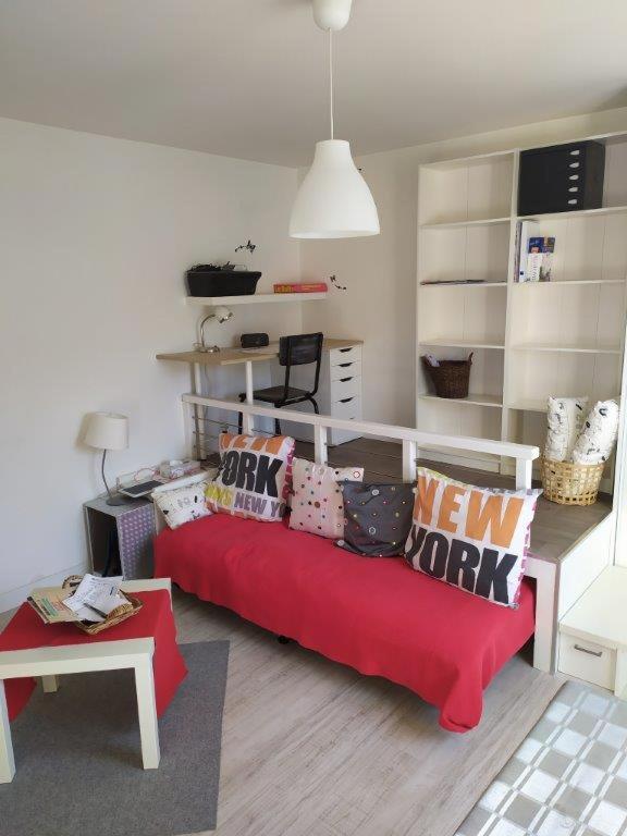 - un salon avec un canapé rouge et des oreillers dans l'établissement Un nid douillet en ville, à Épinal