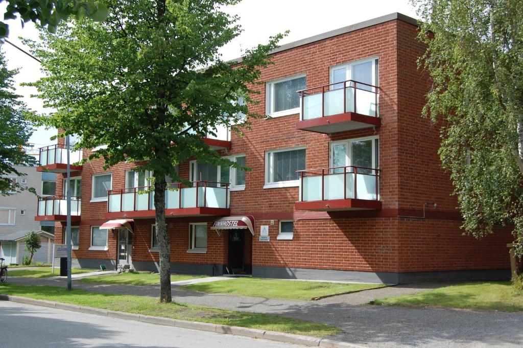 a red brick building with balconies on a street at ISLO Hostel in Joensuu