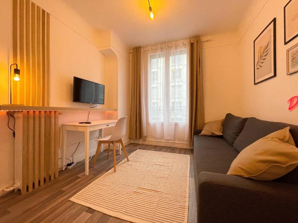 un salon avec un canapé et un bureau dans l'établissement Charming Studio, à Pantin