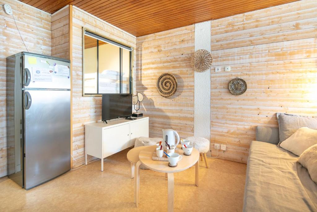 - un salon avec un réfrigérateur et une table dans l'établissement Le Refuge - Appt vue montagne, à Chamrousse