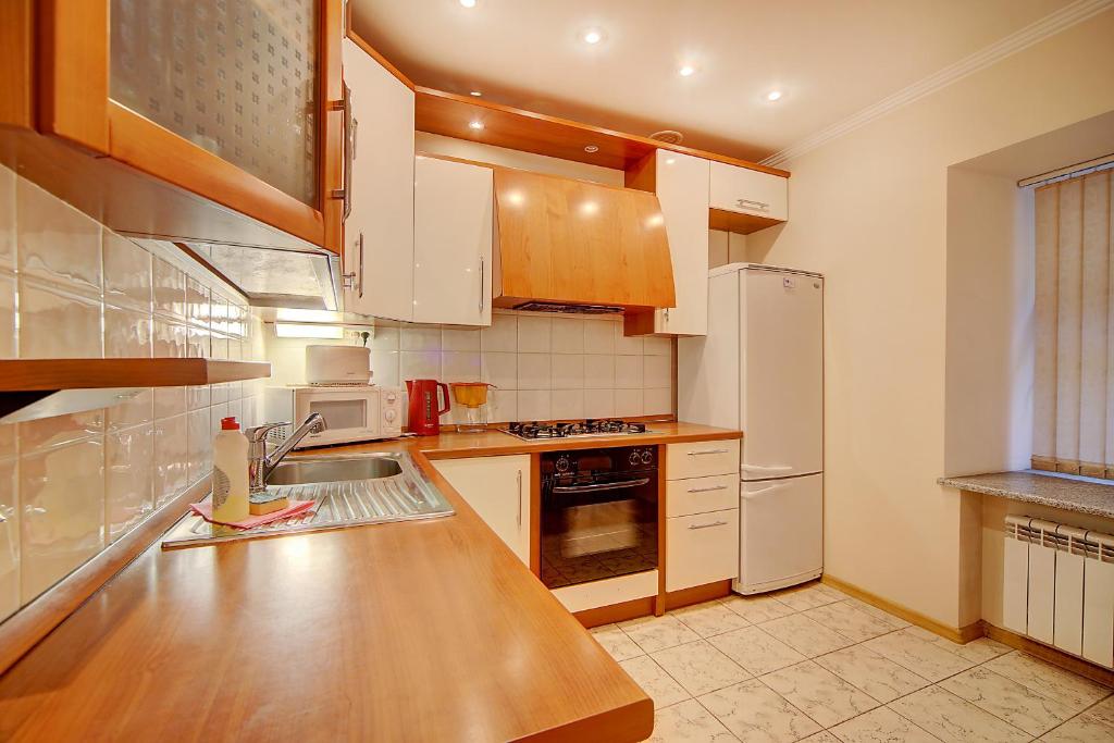 a kitchen with white appliances and a wooden counter top at Apartments ERS Nevsky in Saint Petersburg