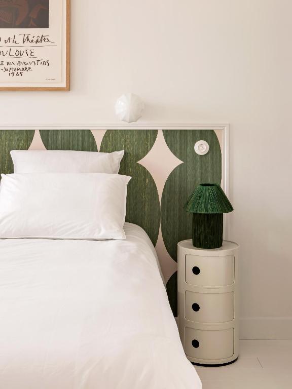 - une chambre avec un lit blanc et une tête de lit verte dans l'établissement Superbe appartement design au coeur de Versailles, tout à pied, à Versailles