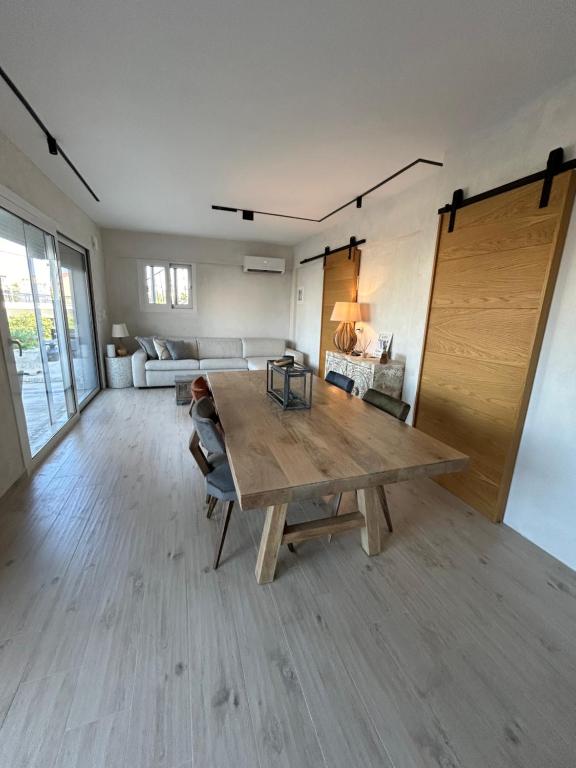 Una sala de estar con una mesa de madera y un sofá. en Calypso, en Chalkida