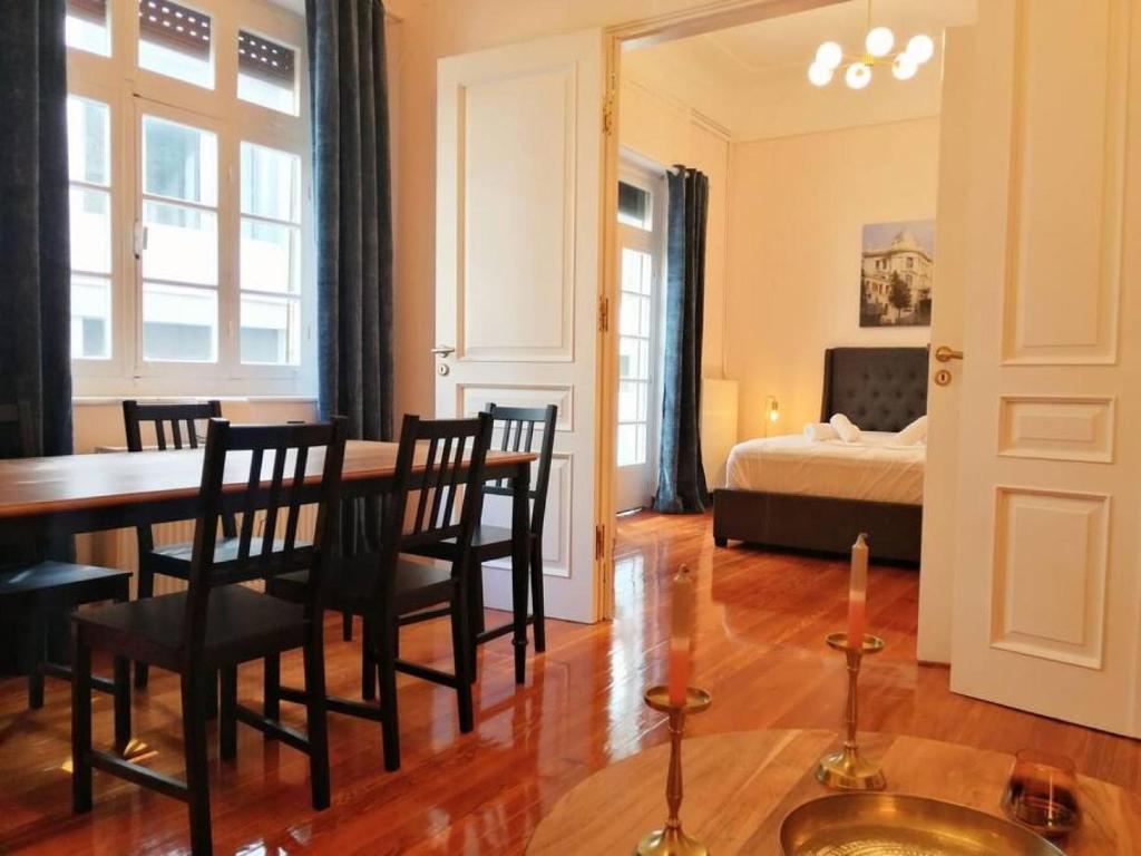 a dining room with a table and chairs and a bed at Elegant apartment in Syntagma square in Athens