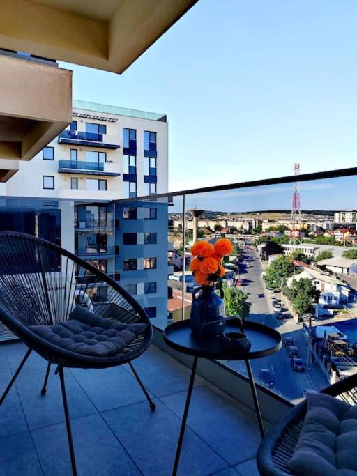 a balcony with a table with a vase with flowers on it at Studio President 52 in Craiova