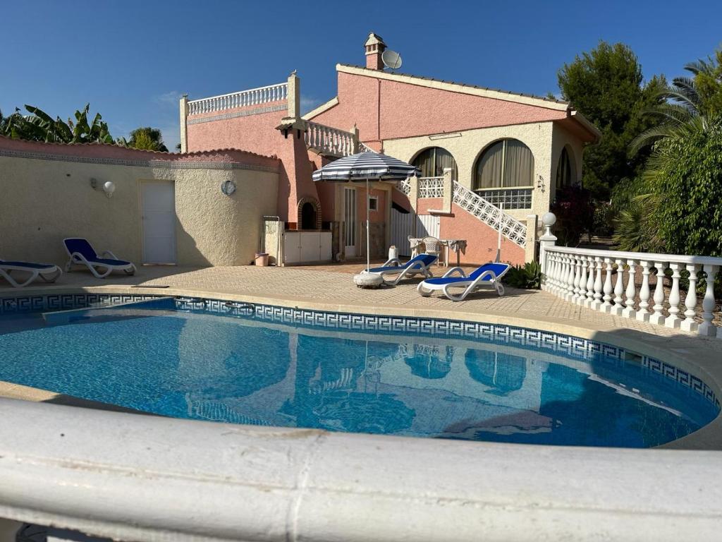 a swimming pool in front of a house at La Casita in Ciudad Quesada