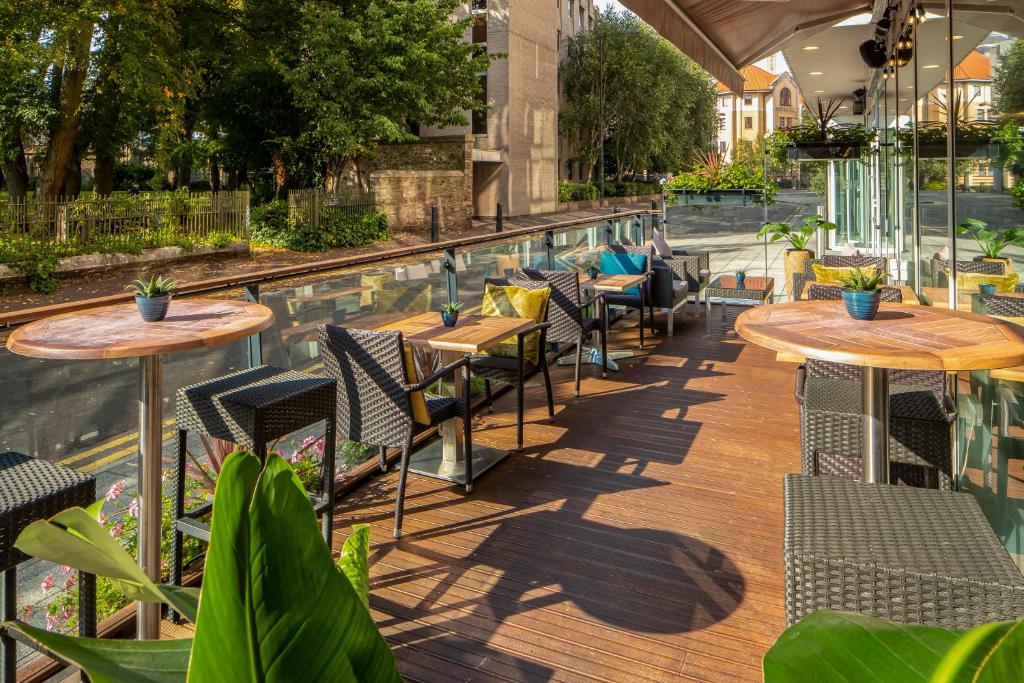 a patio with tables and chairs next to a pool at Hilton Garden Inn Bristol City Centre in Bristol