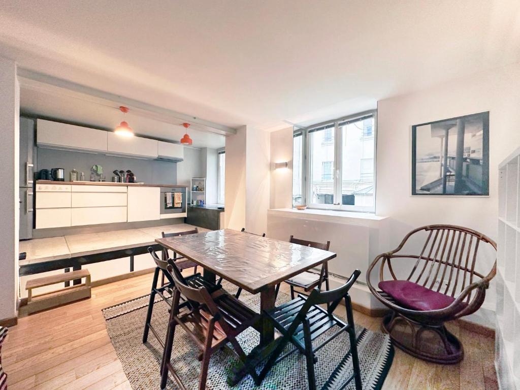 une cuisine avec une table et des chaises dans une pièce dans l'établissement Loft St Martin, à Paris