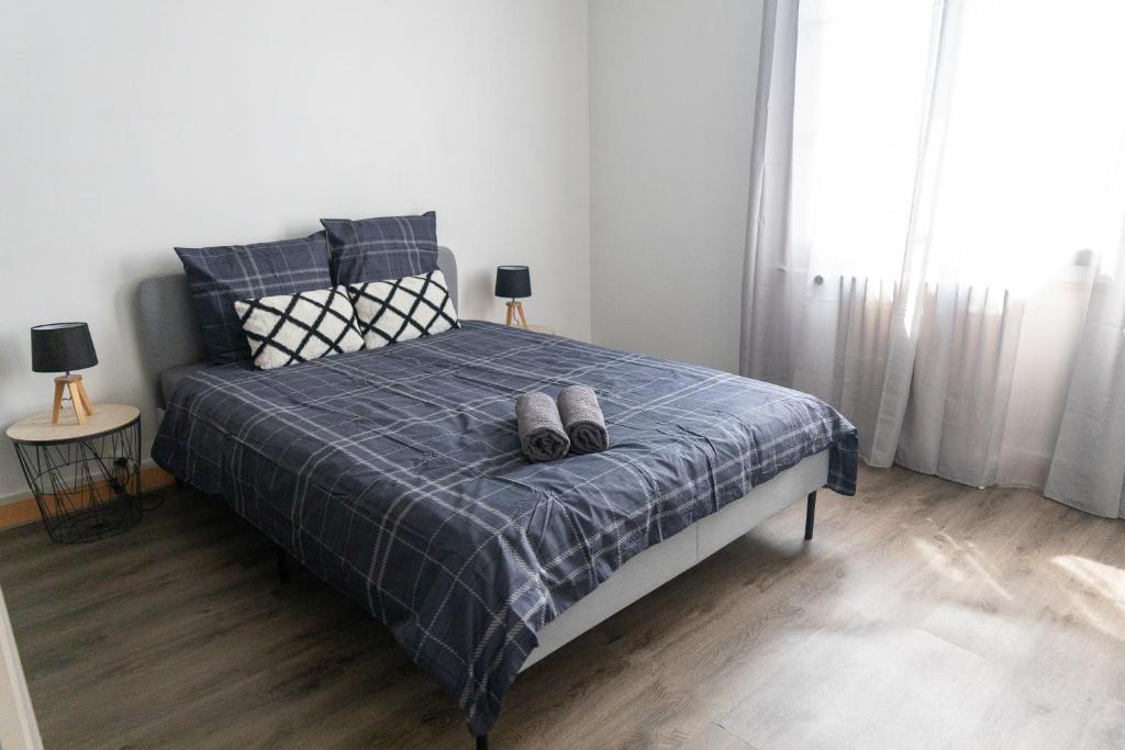 une chambre avec un lit avec deux paires de chaussures dessus dans l'établissement Maison au pied du château N°2, à Châteaudun