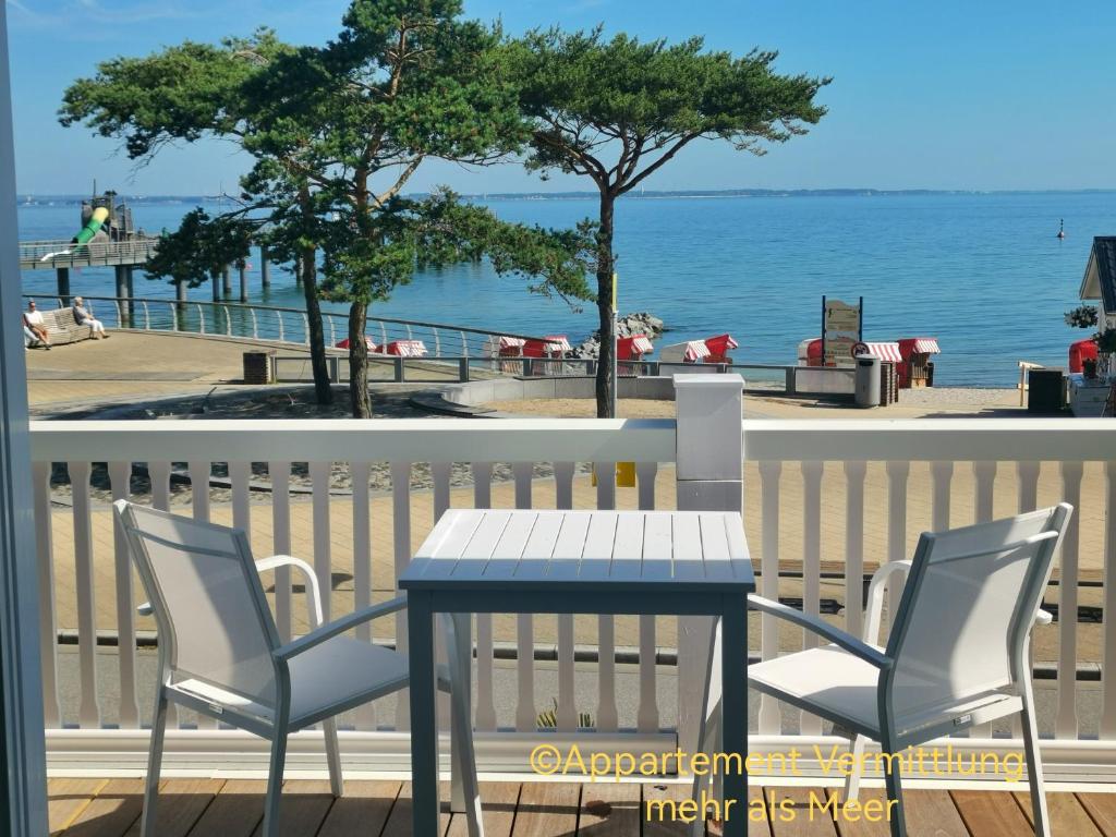 a table and chairs on a balcony with the ocean at Ferienhaus Urban Fewo Beletage 2 bis 6 Personen mit Panorama Meerblick WLAN gegenüber vom Strand in Häven