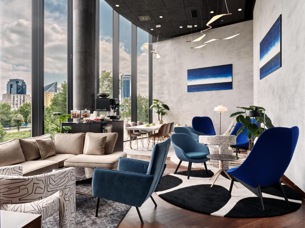 ワルシャワにあるCrowne Plaza - Warsaw - The HUB by IHGのリビングルーム(青い椅子、ソファ付)