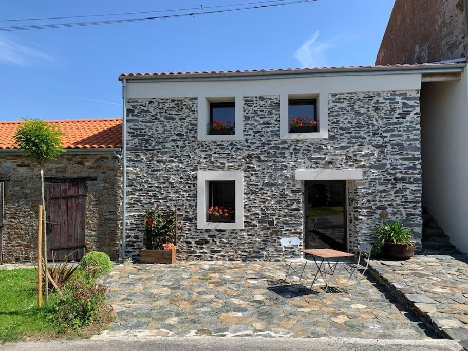 a stone house with a chair in front of it at Le Solier, gîte à la campagne in Frossay