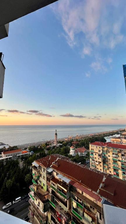Una vista de una ciudad con el océano y edificios. en nunu, en Batumi