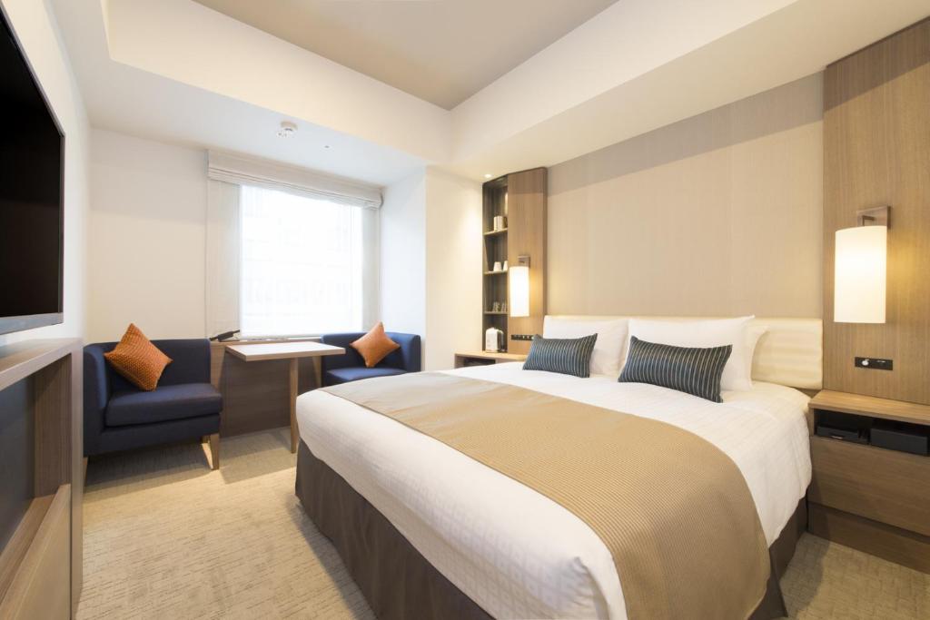 una habitación de hotel con una cama y un televisor en Tokyu Stay Ginza, en Tokio