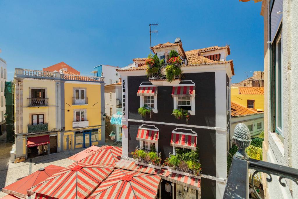a building with flowers on the balconies and an umbrella at Mercy House - BY Y Concept in Setúbal