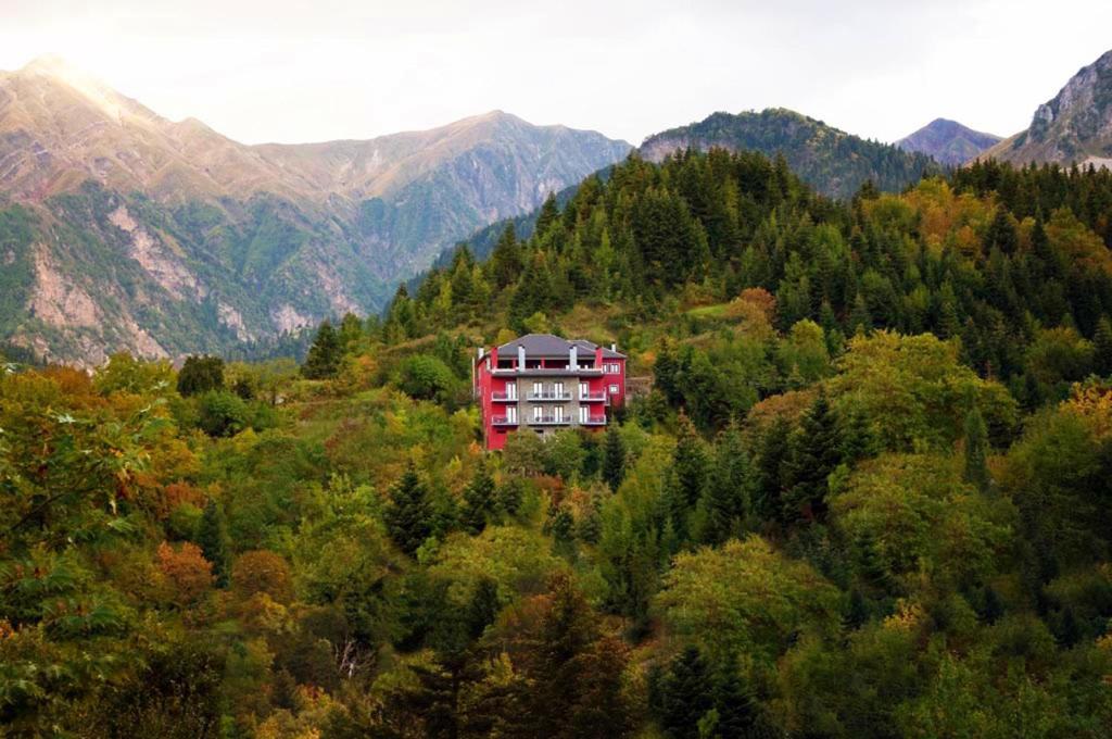 une grande maison rouge au milieu d'une forêt dans l'établissement Agathi, à Pramanta