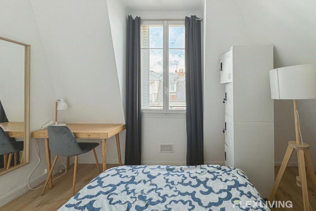 une chambre avec un lit, un bureau et une fenêtre dans l'établissement Flexliving - room - Houel, à Paris