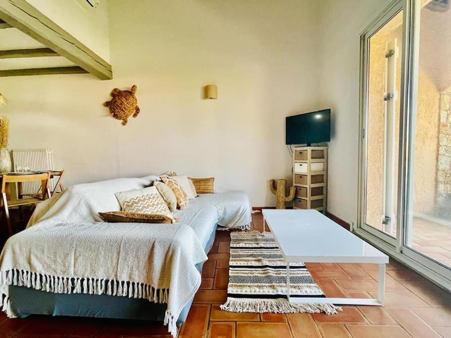 une chambre avec un lit, une table et une télévision dans l'établissement L'Etoile du Port de St Aygulf, à Fréjus