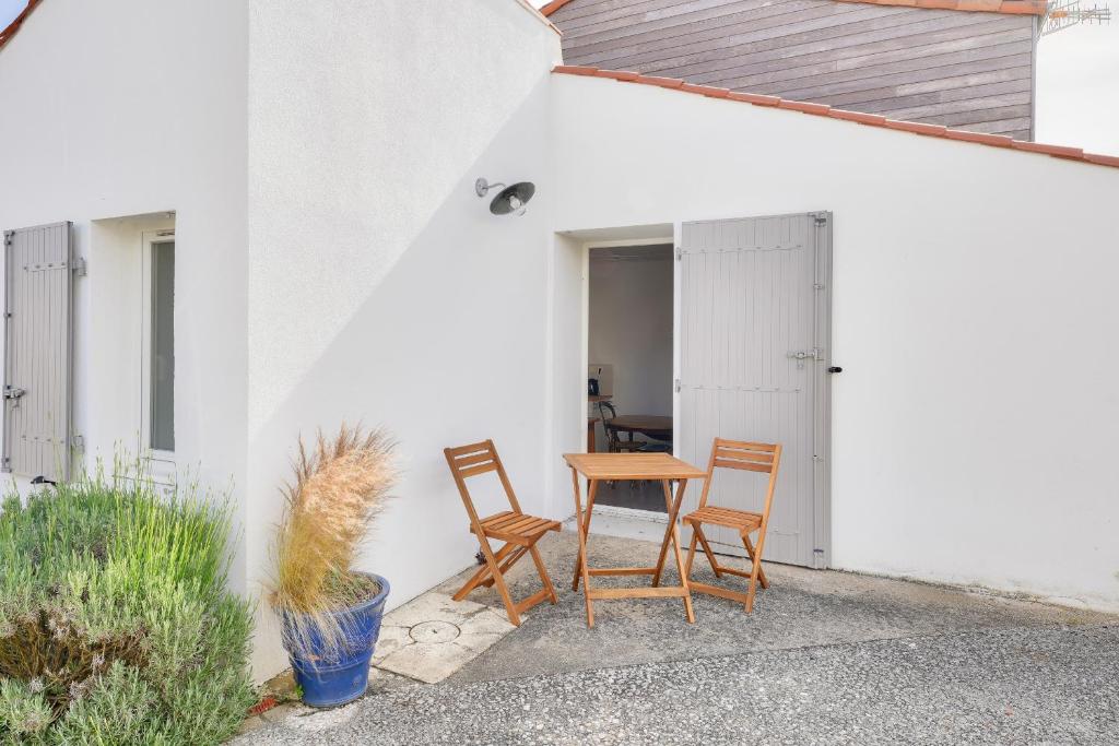 d'une terrasse avec 2 chaises et une table en bois. dans l'établissement Sejour calme, 1,5 km de la plage de la Terriere, à La Tranche-sur-Mer