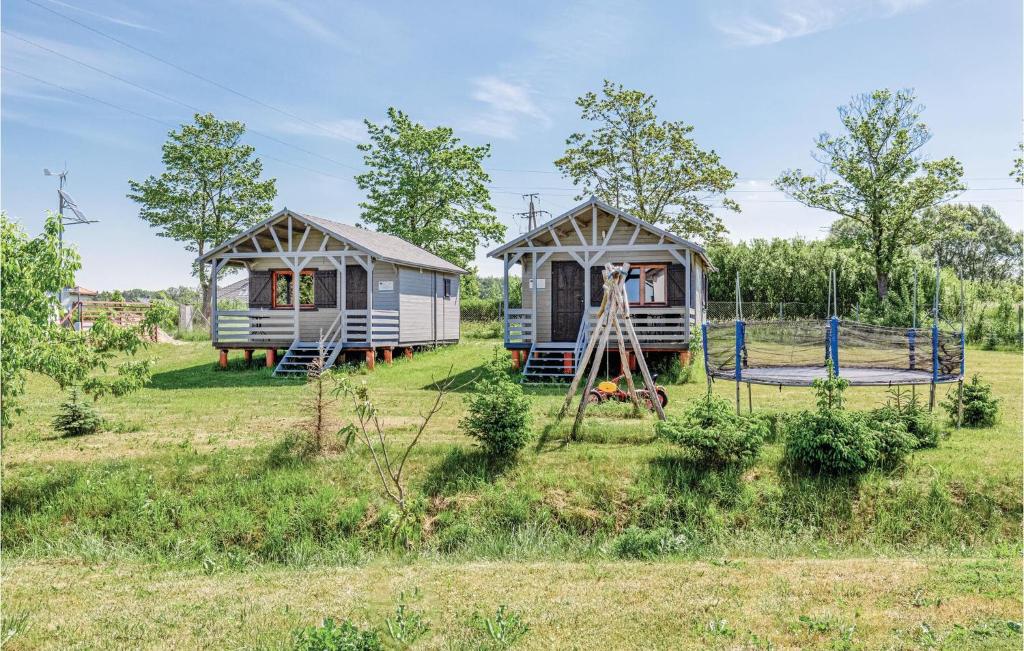 dwie przyczepy mieszkalne na polu z placem zabaw w obiekcie Nice Home In Mscice With Wifi w mieście Mścice