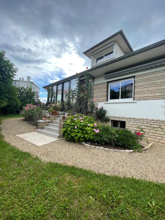 une maison avec quelques fleurs dans la cour avant dans l'établissement Le jardin des Vérottes, à Beaune