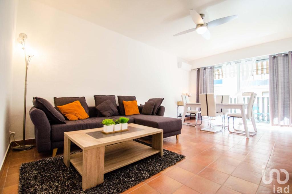 una sala de estar con un sofá y una mesa en Magnifique appartement proche des plages plus garage privé, en Antibes