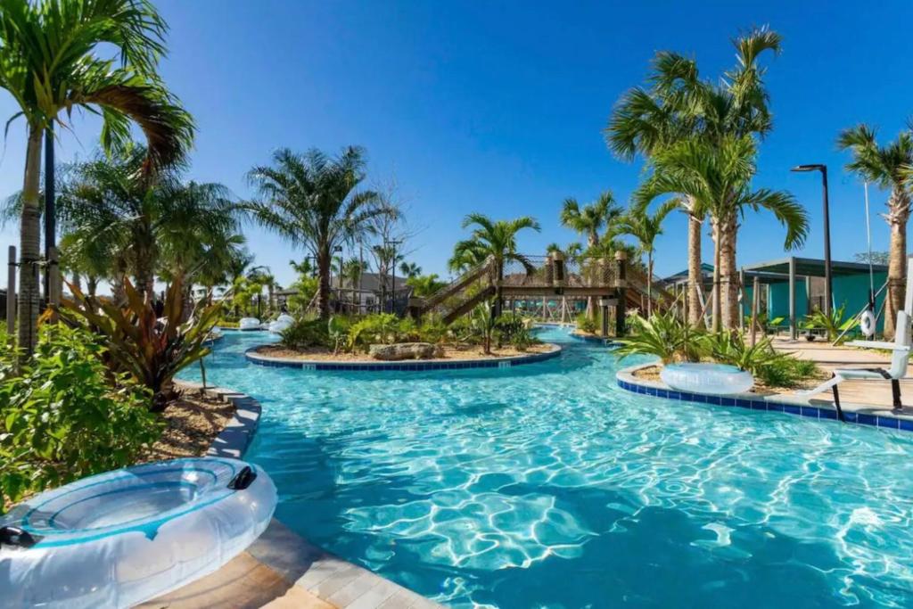 une piscine dans un complexe hôtelier avec des palmiers dans l'établissement Condominium villas near Disney Orlando Florida, à Kissimmee