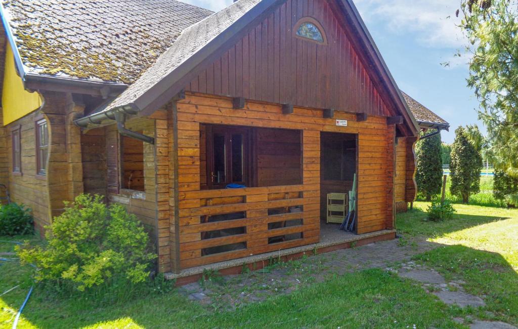 a log cabin with a large window in a yard at 2 Bedroom Nice Home In Mscice in Mścice