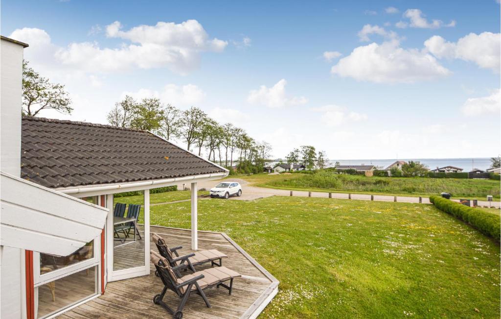 a house with two benches on a deck with a yard at Three-Bedroom Holiday Home In Sjolund in Sjølund