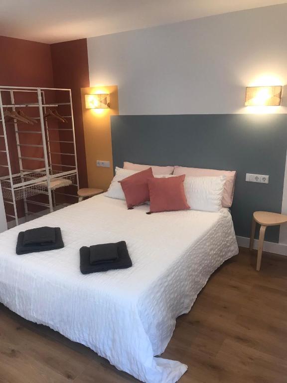 a bedroom with a large white bed with two towels on it at Apartamento Torreón in Foz