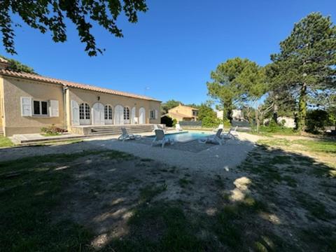 une maison avec trois chats assis dans une cour dans l'établissement la Villa Charme et Confort, à Chamaret