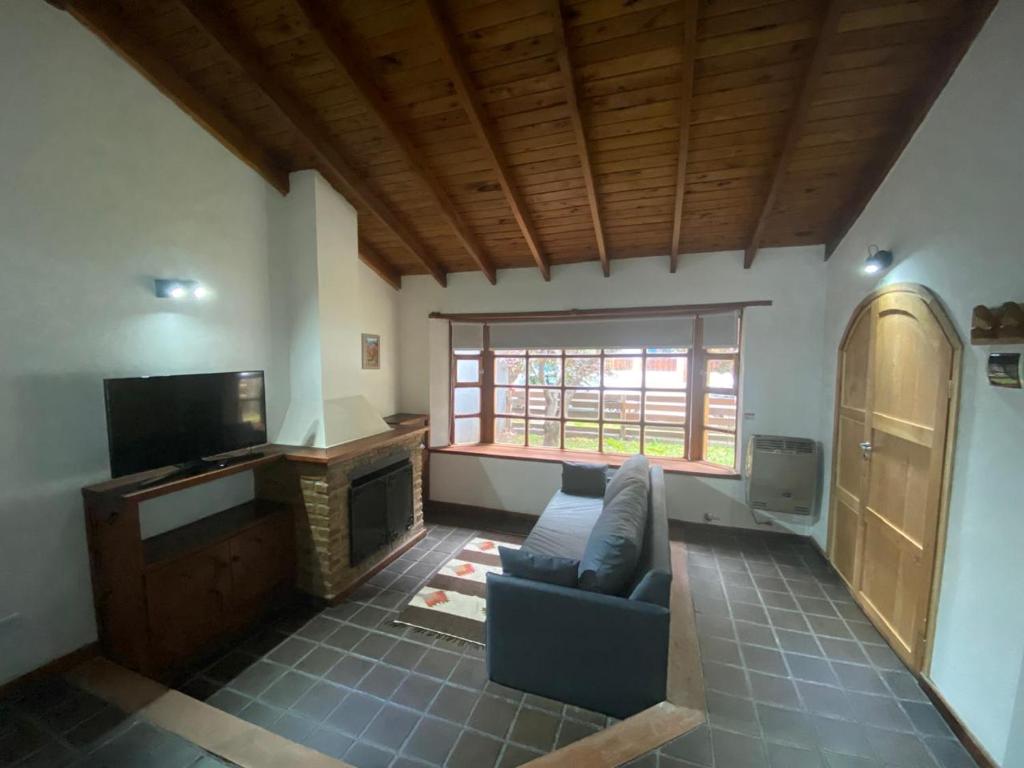a living room with a couch and a television at Departamento El Origen-SMA in San Martín de los Andes