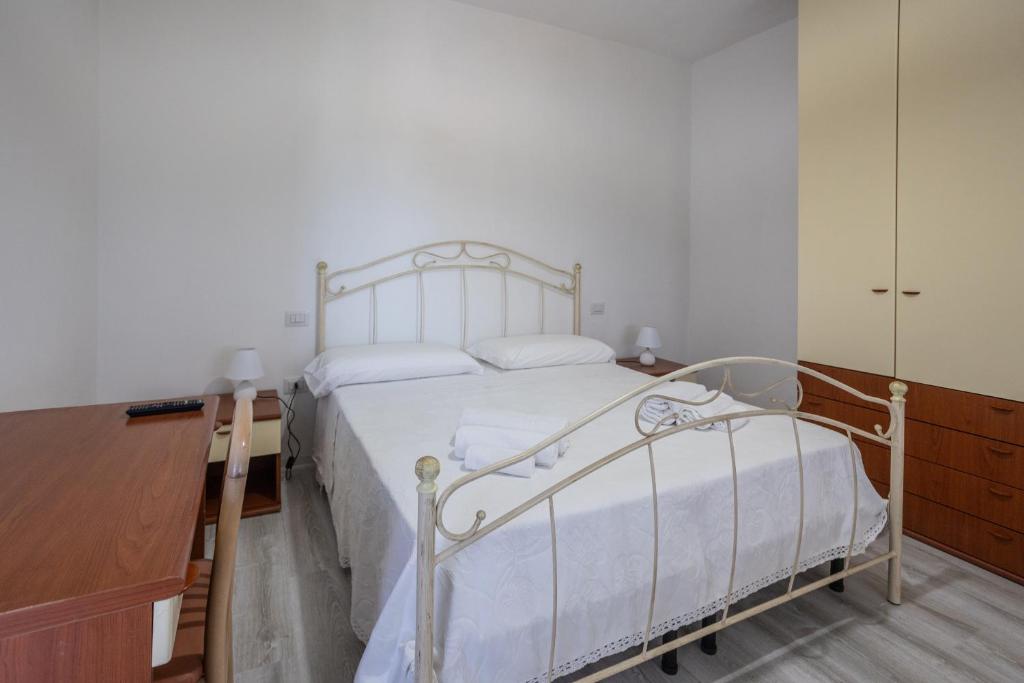 マラテーアにあるB&B La Casa di Carolinaの白いベッドとドレッサーのある寝室