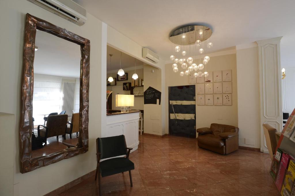 a living room with a mirror and a chair at Hotel Tourist in Turin