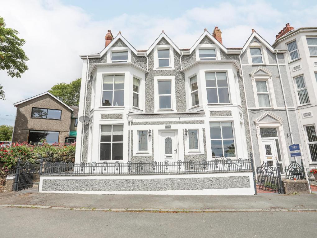 una gran casa blanca con una valla delante en Llwyn Onn, en Criccieth